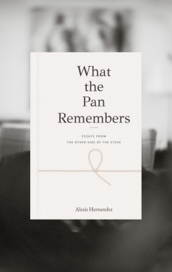 A book cover for 'What the Pan Remembers' by Alexis Hernandez, displayed against a blurred grayscale background of a kitchen interior.
